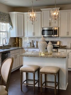 a kitchen with two stools and a center island in front of a stove top oven