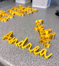 yellow letters spelling out the word idea on a gray counter top with other items in the background