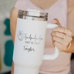 a woman holding a coffee mug with the words don't be tachy taylor on it