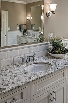 a bathroom vanity with marble counter top and sink