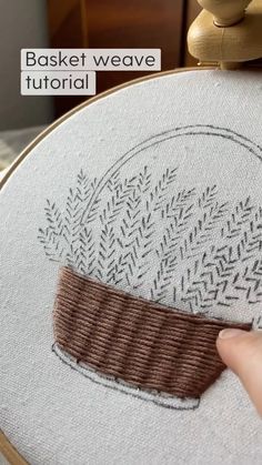 a hand is stitching on the back of a white and brown basket weave pattern