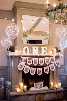 a mantel with balloons, candles and pictures on it in front of a fireplace