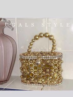 Elevate your evening look with our Metal Cage Evening Bag. With a luxurious gold metal cage design, adorned with sparkling rhinestones and diamonds, this clutch is perfect for weddings and parties. The intricate hollow-out details add a touch of sophistication to any outfit. Glamorous Gold Clutch With Pearl Handle, Glamorous Metal Bag For Events, Glamorous Metal Evening Bag For Events, Luxury Metal Evening Bag For Party, Gold Clutch With Rhinestones For Night Out, Gold Evening Clutch With Pearl Handle, Gold Rhinestone Clutch For Night Out, Gold Metal Bag For Party, Gold Metal Evening Bag For Parties