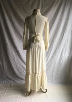 "1970s prairie dress label- Patty O'Neil cream color w/oatmeal specks cotton muslin feel lace trim- synthetic feel long sleeve w/button cuff v neck w/collar tie back from front high waist band zip up back w/hook eye top closure floor to ankle length, more or less depending on wearer's height very good vintage condition, light wear label size 7 (see below) fits like a modern small, please go by measurements measures, lying lat, shoulder-13 3/4\" chest-17\" waist-13\" (26\" waist total) hip-21\" s Beige Cotton Prairie Dress For Summer, 1970s Fitted Maxi Dress For Daywear, 1970s Fitted Maxi Dress, Cream Ruffled Maxi Dress For Fall, Beige Vintage Dress With Lace Trim, Beige Cotton Prairie Dress For Daywear, Fall Cream Dress With Lace Trim, Cream Lace Trim Dress For Fall, Beige Cotton Maxi Dress With Ruffles