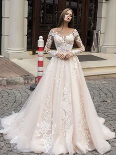 a woman standing in front of a building wearing a wedding dress