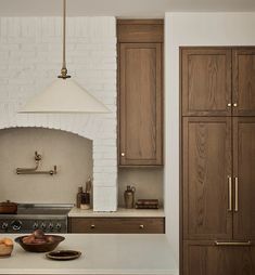 a kitchen with an oven, sink and cabinets next to a wall mounted stove top