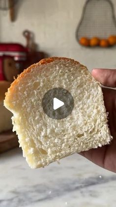 a person holding a piece of bread in their hand with the video on it's screen