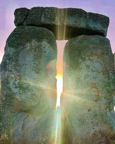 two large rocks with the sun shining through them