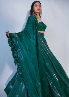 Emerald green pleated flared lehenga with sequins embellishments. Paired with bustier style blouse with floral embroidery & organza dupatta with paisley motif embroidery. Sequins Lehenga, Embroidery Organza, Flared Lehenga, Motif Embroidery, Paisley Motif, Green Sequins, Organza Dupatta, Style Blouse, Custom Tailoring