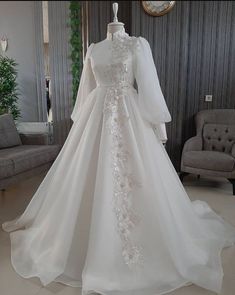 a white wedding dress on display in a room