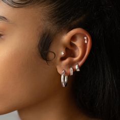 a close up of a person with ear piercings on their ears and behind the ear