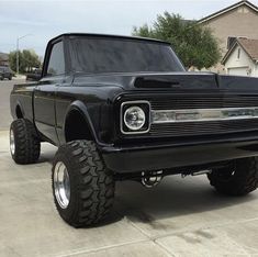 a black pickup truck parked in front of a house