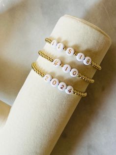 Celebrate a date! Wear your favorite number, wedding date, your child's birthday or sports number with these 18k gold filled beaded number bracelets. Gold filled beads are much more tarnish resistant and long lasting opposed the the more commonly seen gold plated. Size options for girls and women. These bracelet layer well with others so add this to your stack! Beaded on high quality stretch cord and secured. -  4mm 18k gold filled beads       acrylic number letters -  Enter your numbers in pers Number Bracelets, Date Wear, Date Bracelet, Number Jewelry, Number Beads, Bracelet Wedding, Gold Number, Anniversary Dates, Layered Bracelets