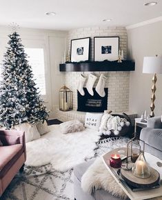 a living room filled with furniture and a christmas tree in front of a fire place