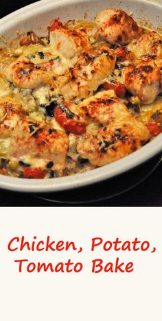 chicken, potato, and tomato bake in a white casserole dish on a black surface