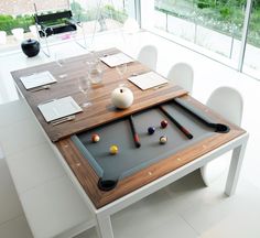 a pool table is set up in the middle of a dining room with white chairs