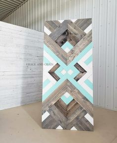 a large wooden sign sitting in front of a white wall with blue and grey designs on it