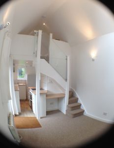 the view through a fish eye lens shows a staircase and kitchen