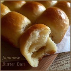 some bread rolls are cut in half on a cutting board