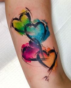 a colorful heart tattoo on the arm