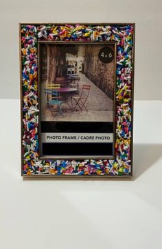 an artistic photo frame with colorful sprinkles on the outside and inside it