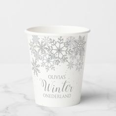 a white cup with blue snowflakes on it and the words winter onederland