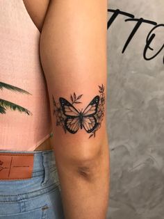 a woman's arm with a butterfly tattoo on the left side of her arm