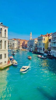 several boats floating in the water near buildings