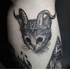 a black and white photo of a cat with horns on it's back leg