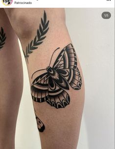 a woman's leg with a butterfly tattoo on it and leaves around the legs