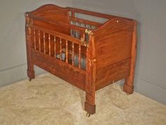 an old wooden crib in the corner of a room with no mattresses on it