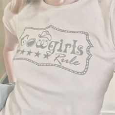 a woman wearing a t - shirt that says cowgirl's ride on it