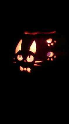 two pumpkins with faces carved into them in the dark