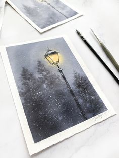 two pictures of a street light on a table with paintbrushes next to it