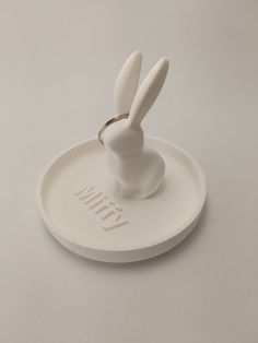 a white ring holder with a rabbit on it