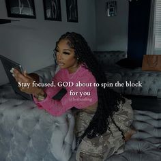 a woman sitting on top of a couch with a laptop computer in her hand and the caption says stay focused, god about to spin the block for you