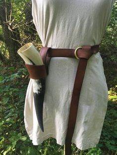 the back of a white dress with brown leather straps and an antelope head on it