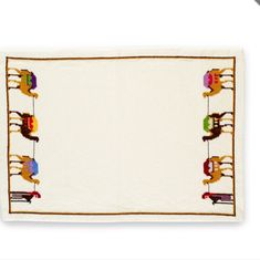 an embroidered placemat with cats on the front and two dogs on the back, hanging from clothes pegs