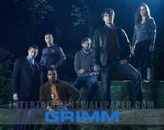 a group of people that are sitting on some steps in front of the words grimm