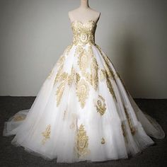 a white and gold wedding dress on display