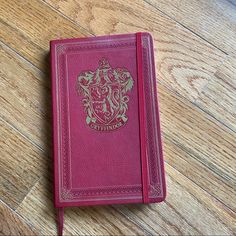 a red book sitting on top of a wooden floor