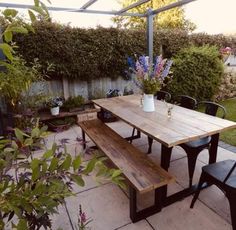 a wooden table sitting under an umbrella on top of a patio