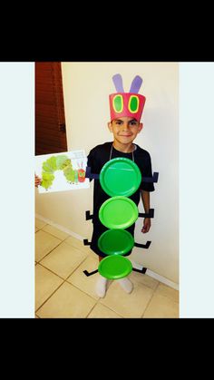 a young boy dressed up as a caterpillar with green plates on his feet