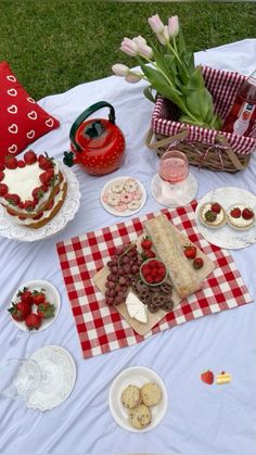 a table topped with lots of cakes and desserts on top of a checkered cloth