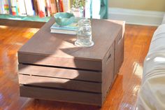 a wooden table with two drawers sitting on top of it next to a white couch