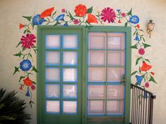 a green door with flowers painted on it