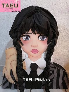 a doll with long black hair wearing a tie