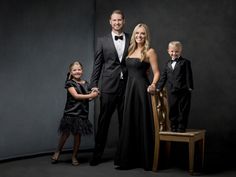 a man and two children are posing for a photo in formal wear with their parents