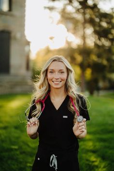 a woman in black shirt holding two stethoscopes