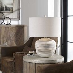 a lamp sitting on top of a table next to a chair in a living room